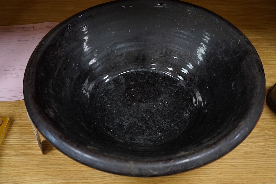 A large 19th century black glazed stoneware dairy bowl, 49cm diameter